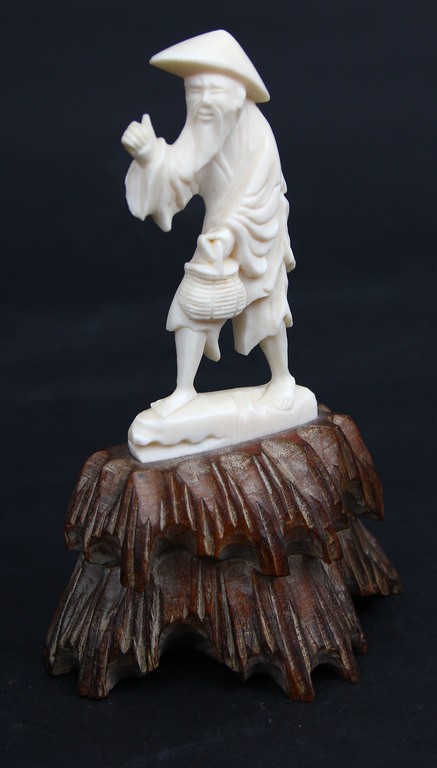 Bone figurine on the wooden base 