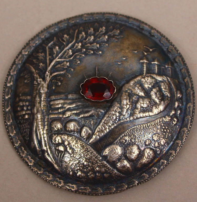 Silver brooch with red stone 
