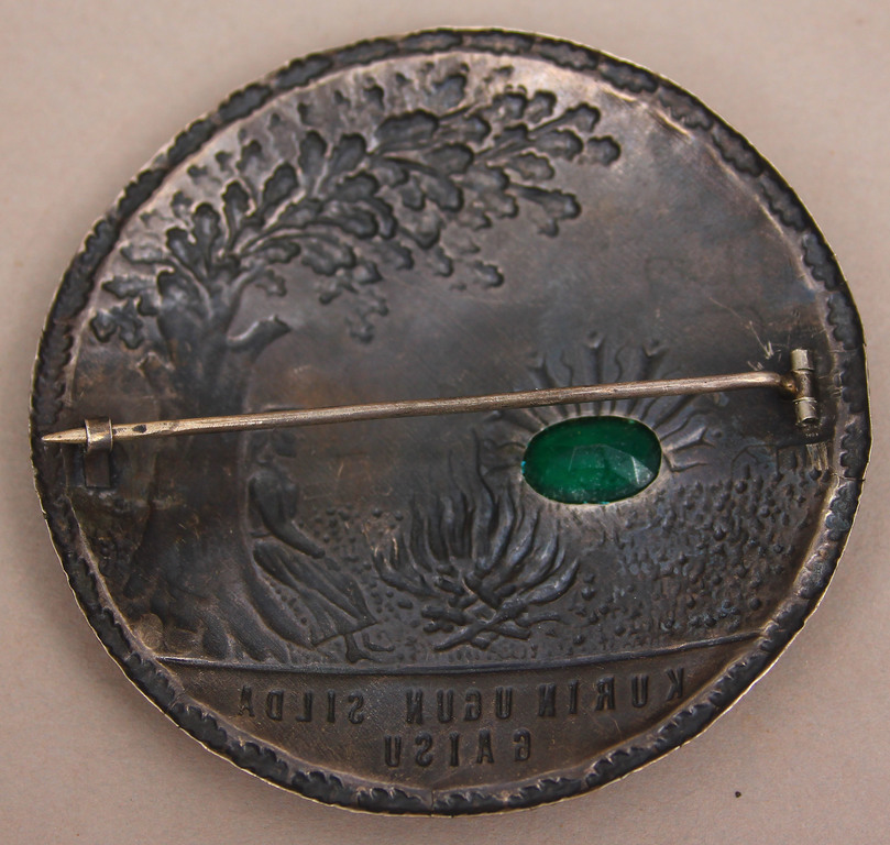 Silver brooch with green stone