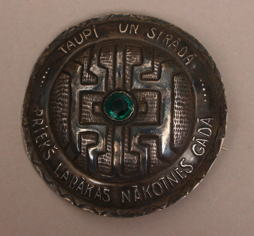 Silver brooch with green stone 