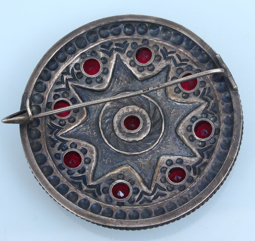 Silver brooch with red stones 