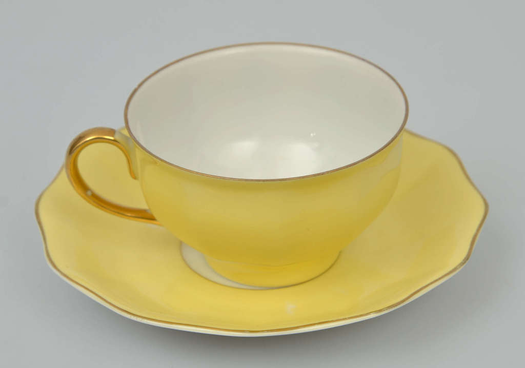 Желтая фарфоровая чашка с блюдцем