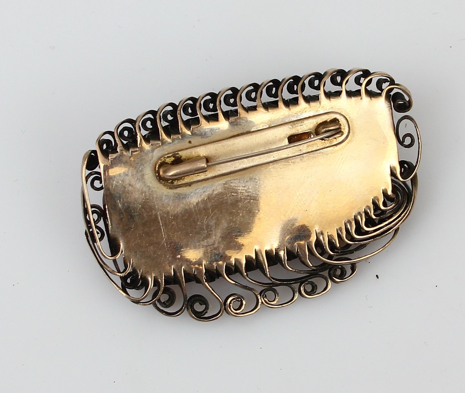 Amber brooch with metal finish