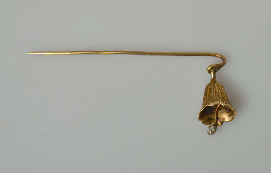 Women's gold brooch in the shape of a flower with a diamond