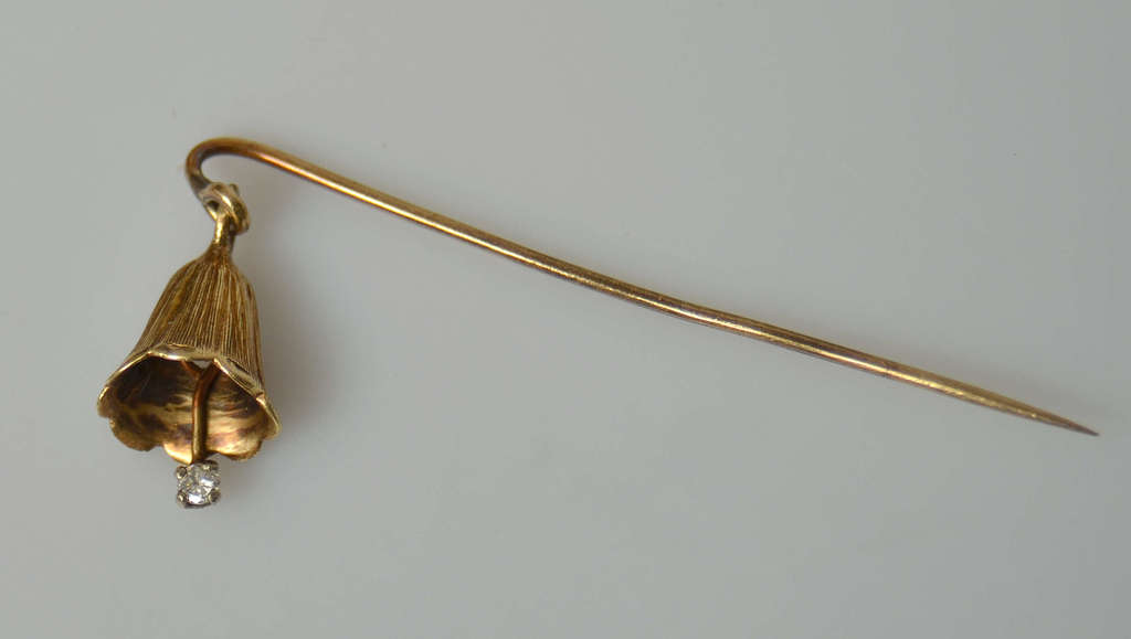 Women's gold brooch in the shape of a flower with a diamond