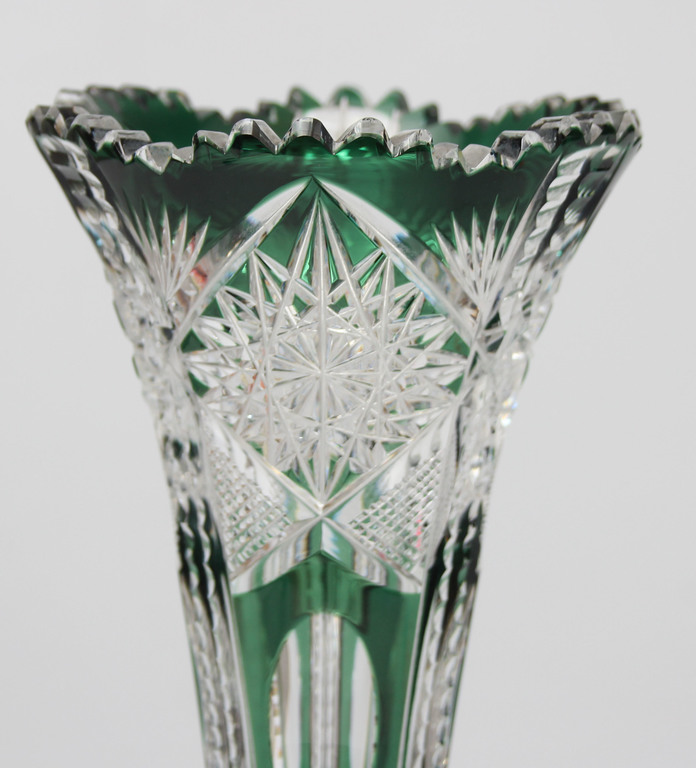 A colored crystal trumpet-shaped vase on a leg