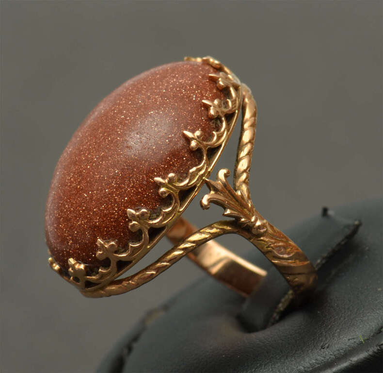 A gold ring with a large aventurine