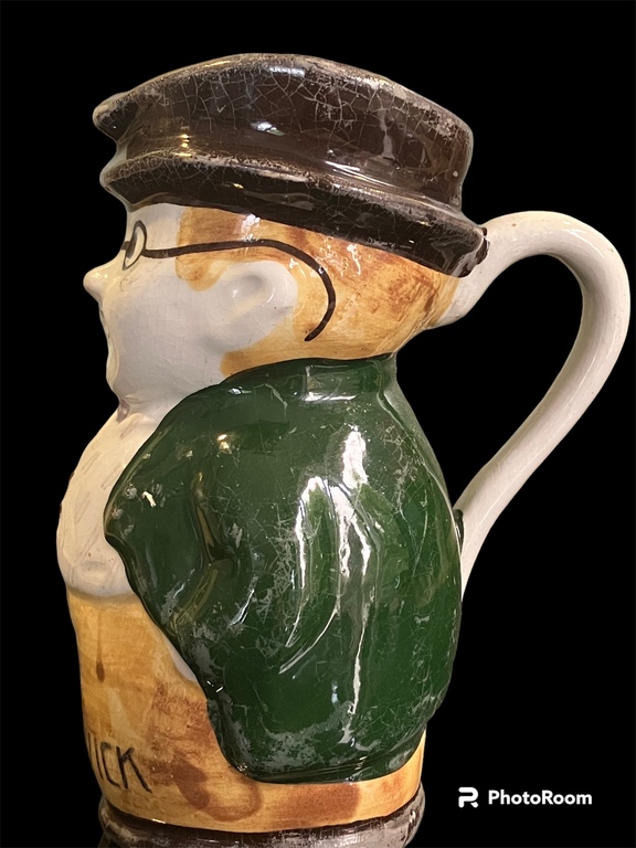  14,5 cm reta krāsojuma un izpildījuma porcelana kanniņa   vīrs ar ūsiņām zaļajā žaketē bordo brūnajā cepurē