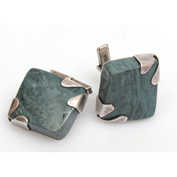 Silver cufflinks with a green colored stone