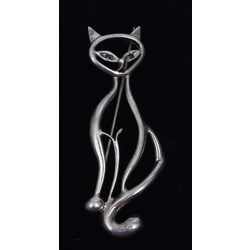 Silver brooch cat with dark colored stones instead of eyes