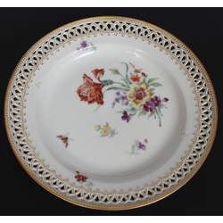 Фарфоровая тарелка с цветочным мотивом и декоративным внешним краем.