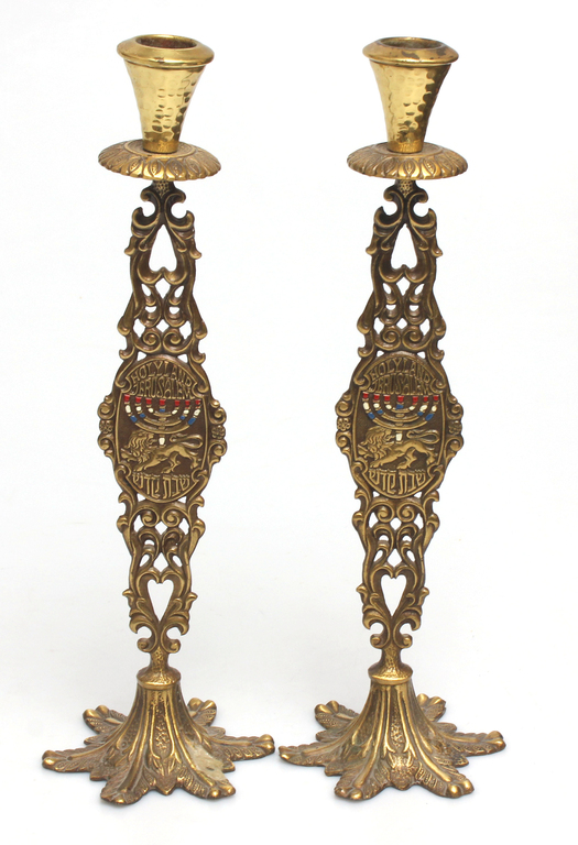 A pair of metal candlesticks with a blue colored stone