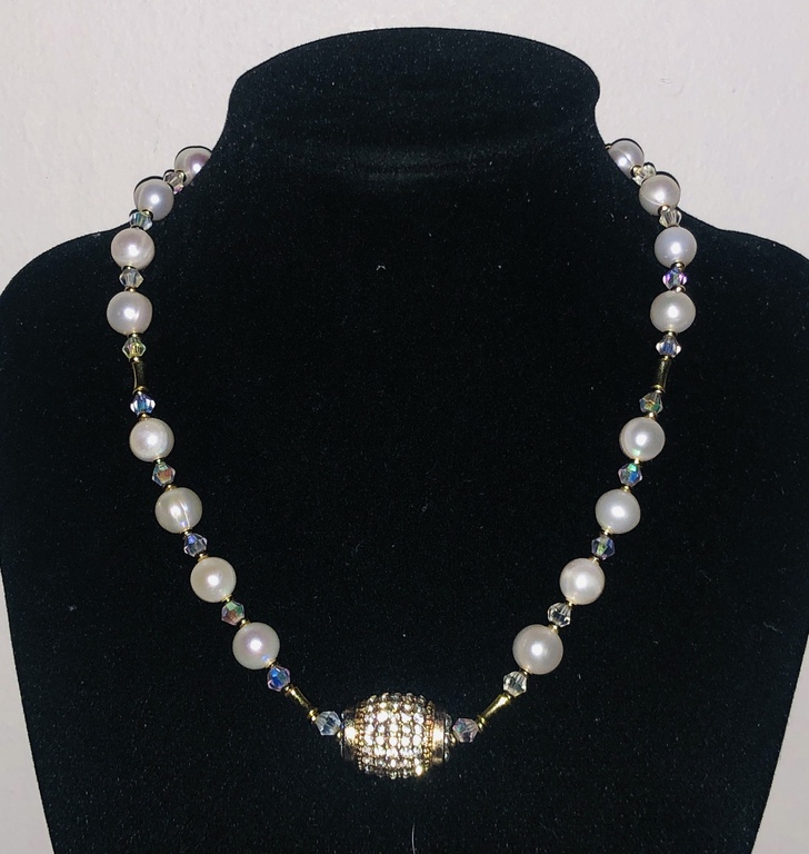 Necklace with freshwater pearls, crystals and other gold-plated elements.