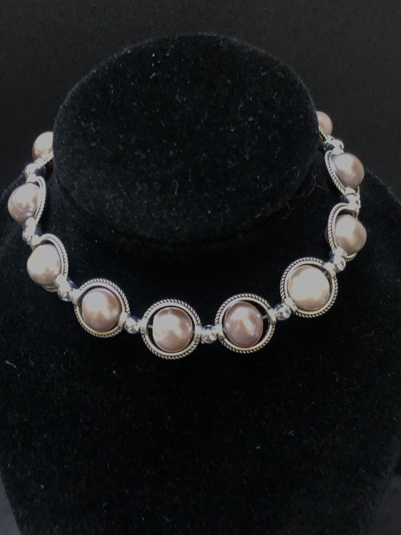 Bracelet with lavender colored beads, zirconia clasp and other metal elements.