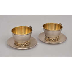 Two metal cups with saucers