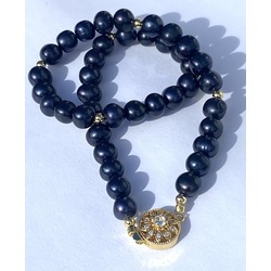 Necklace with dark blue freshwater pearls and gold-plated metal elements.