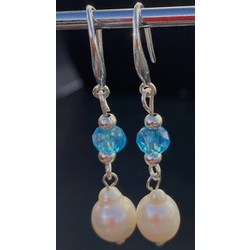 Silver earrings with white freshwater pearls and light blue crystals. 