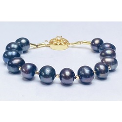 Bracelet with large dark freshwater pearls and metal elements with 14k gold plating.