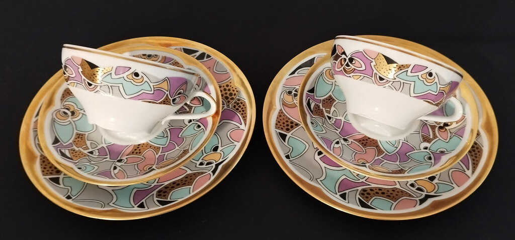 Divas porcelāna tasītes ar apakštasītēm un šķīvi