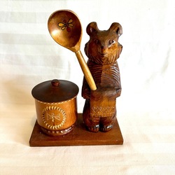 Wooden teddy bear with a jar for honey and a spoon. Wood carving. Old.