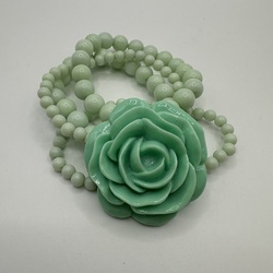 Wrist bracelet made of emerald-colored plastic beads with a large flower. In Art Decor style