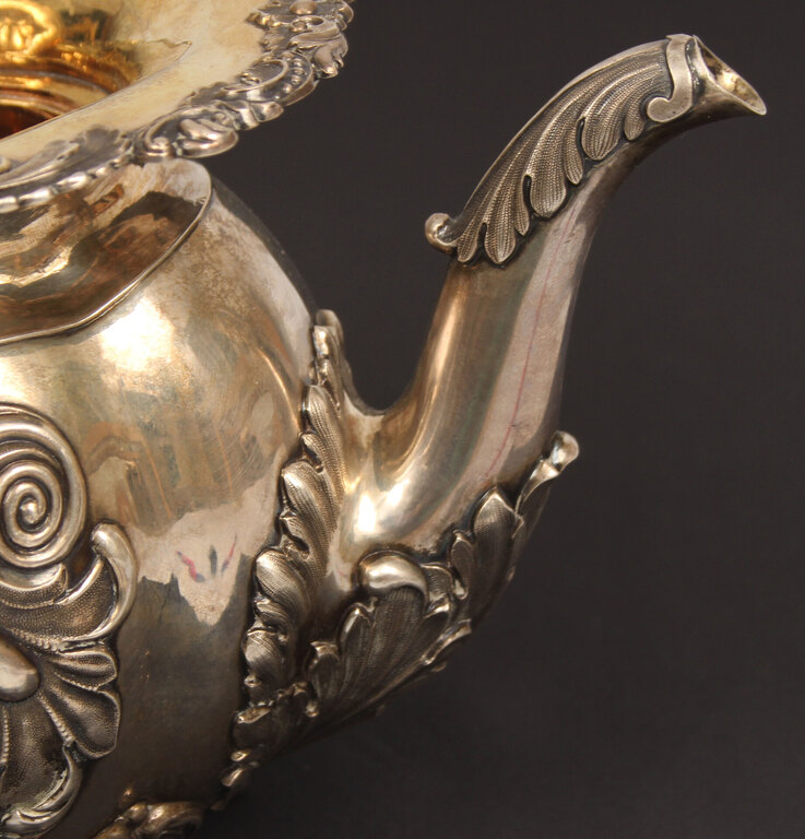 A silver teapot and creamer with gilding