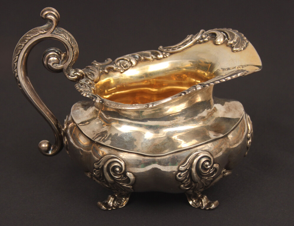 A silver teapot and creamer with gilding